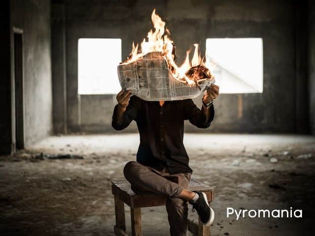 man-holding-a-newspaper-on-fire