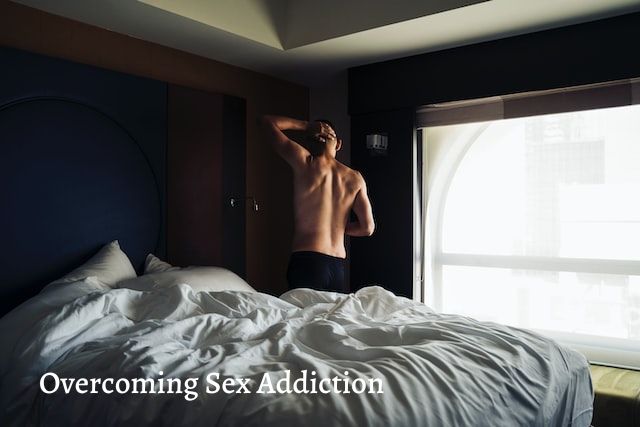 man standing next to a bed