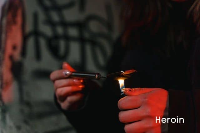 person-lighting-a-spoon-and-a-heroin-sign
