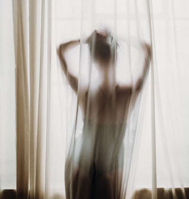 woman-behind-sheer-curtains-