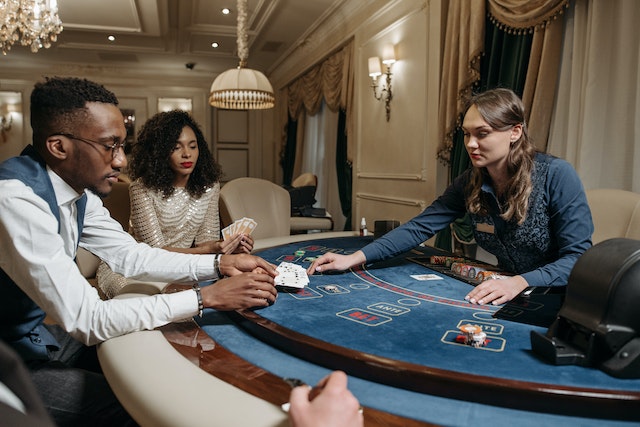 Card dealer passing cards to man and a woman playing poker