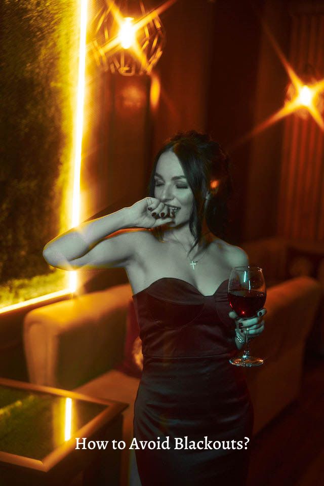 Woman holding glass of red wine.