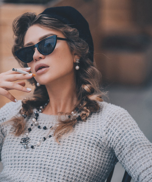 woman in sunglasses smoking a cigarette