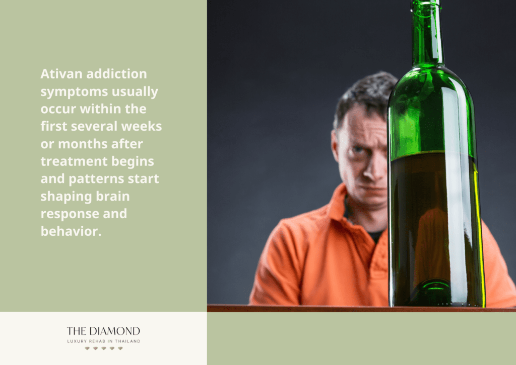 A person in orange shirt with a wine bottle in front of him.